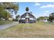 Gray house with white accents, a wooden door, and a spacious lawn at 119 Leon Ave, Deland, FL 32720