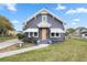 Gray house with white accents, a wooden door, and a spacious lawn at 119 Leon Ave, Deland, FL 32720