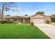 Tan house with stone accents, landscaped lawn, and a two-car garage at 1266 Juliana Pl, Orlando, FL 32807