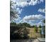 Inviting backyard view with lush greenery and open space under a beautiful blue sky with fluffy clouds at 1318 Lucky Pennie Way, Apopka, FL 32712