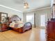 Elegant main bedroom with a king-size bed and hardwood floors at 1318 Lucky Pennie Way, Apopka, FL 32712