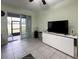 Living room with a white media console and sliding glass doors leading to a patio at 15343 Willow Arbor Cir, Orlando, FL 32824