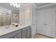 Double vanity bathroom with gray cabinets and large mirror at 16205 Saint Kitts Cir, Clermont, FL 34714