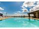 Beautiful pool with clear water, lined with chairs, and a covered lounge area with a bright sky above at 16800 Bolsena Dr, Montverde, FL 34756