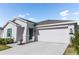 White one-story house with green accents and a two-car garage at 2037 Freemark St, Osteen, FL 32764