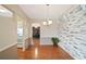 Open dining area featuring hardwood floors, brick accent wall, and modern light fixture at 213 Oakland Ave, Sanford, FL 32773