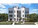 Modern three-story townhome with gray and white exterior, balconies, and lush landscaping at 2229 Valentine Aly, Orlando, FL 32804