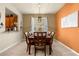 Formal dining room with large wooden table and orange accent wall at 2549 Archfeld Blvd, Kissimmee, FL 34747