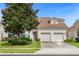 Two-story house with beige exterior, double garage, and landscaping at 2549 Archfeld Blvd, Kissimmee, FL 34747