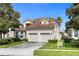 Two-story house with beige exterior, double garage, and landscaping at 2549 Archfeld Blvd, Kissimmee, FL 34747