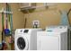 Bright laundry room with washer, dryer, and storage shelves at 2549 Archfeld Blvd, Kissimmee, FL 34747