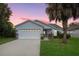 House exterior at dusk, featuring a two-car garage and landscaping at 2610 Autumn Creek Cir, Kissimmee, FL 34747