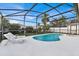 Kidney-shaped pool with screened enclosure and lounge chairs at 2610 Autumn Creek Cir, Kissimmee, FL 34747