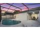 Scenic pool at sunset with screened enclosure, patio furniture, and lounge chairs at 2610 Autumn Creek Cir, Kissimmee, FL 34747