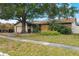 Damaged house with boarded windows and overgrown landscaping at 2667 Fitzhugh Rd, Winter Park, FL 32792