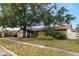 House with fire damage, overgrown landscaping, and boarded windows at 2667 Fitzhugh Rd, Winter Park, FL 32792