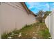 Side yard with patchy grass and a damaged fence at 2667 Fitzhugh Rd, Winter Park, FL 32792