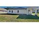 Rear view of a single-story house with covered patio and grassy backyard at 3342 Saint Vincent Ln, Clermont, FL 34711