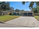 Ranch style home with carport, mature landscaping, and a large yard at 402 Oak Lynn Dr, Orlando, FL 32809