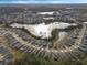 Aerial view of a residential area with houses surrounding a lake at 4530 Tahoe Cir, Clermont, FL 34714