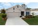 One-story house with beige exterior, neatly landscaped yard, and a two-car garage at 4530 Tahoe Cir, Clermont, FL 34714