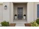 Front entry with a dark gray door, light beige walls, and potted plants at 4530 Tahoe Cir, Clermont, FL 34714