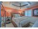 Guest bedroom with coral walls, queen bed, and ceiling fan at 5501 S Atlantic Ave # 4150, New Smyrna Beach, FL 32169