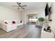 Living room with white sectional, sliding doors to patio, and wood-look floors at 6145 Citrus Grove Ct, St Cloud, FL 34771