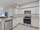 Modern kitchen with white cabinets, granite counters, and stainless appliances at 715 Siena Palm Dr, Celebration, FL 34747