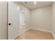 Hallway with an open doorway and light, neutral walls at 7884 Broken Arrow Trl, Winter Park, FL 32792