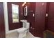 Bathroom with burgundy walls, pedestal sink, and toilet at 913 Carlson Dr, Orlando, FL 32804