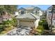 Beige two-story home featuring a tile roof, two-car garage, and well-manicured front lawn at 9132 Via Bella Notte, Orlando, FL 32836