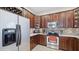 A well-lit kitchen with stainless steel appliances, dark wood cabinets, and tile backsplash and flooring at 9132 Via Bella Notte, Orlando, FL 32836