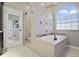 Spa-like bathroom with soaking tub, walk-in shower, and tile flooring at 9451 Brownwood Ct, Oviedo, FL 32765