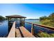 Wooden dock with gazebo overlooking serene lake at 9451 Brownwood Ct, Oviedo, FL 32765