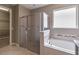 Bathroom showcasing a glass-enclosed shower, soaking tub, and tile accents, designed for relaxation at 1040 Sadie Ridge Rd, Clermont, FL 34715