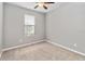 Bedroom features neutral walls, plush carpet, a ceiling fan, and natural light at 1040 Sadie Ridge Rd, Clermont, FL 34715