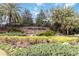 Stone sign at Highland Ranch entrance with lush landscaping and palm trees at 1040 Sadie Ridge Rd, Clermont, FL 34715