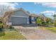 Gray house with stone accents and a paved driveway at 1040 Sadie Ridge Rd, Clermont, FL 34715