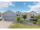 Gray house with stone accents, landscaping, and a paved driveway at 1040 Sadie Ridge Rd, Clermont, FL 34715