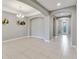 Spacious foyer with tile flooring, elegant archways, chandelier, and a welcoming front door with glass detailing at 1040 Sadie Ridge Rd, Clermont, FL 34715