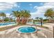 Community pool featuring a jacuzzi, palm trees, and a covered seating area perfect for relaxation at 1040 Sadie Ridge Rd, Clermont, FL 34715