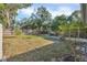 Large backyard with grassy area, trees, and a wooden fence at 1107 Lantana Dr, Eustis, FL 32726