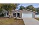 Ranch style home with a grey exterior and a white garage door at 1107 Lantana Dr, Eustis, FL 32726