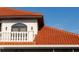 Close-up of architectural details featuring a red tile roof and decorative windows and a light fixture at 11148 Lane Park Rd, Tavares, FL 32778