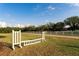 Spacious horse arena featuring well-maintained fencing and equestrian jump infrastructure under a clear blue sky at 11148 Lane Park Rd, Tavares, FL 32778