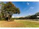 Scenic horse arena with white fencing, equestrian jump infrastructure, and lush green pastures under a clear blue sky at 11148 Lane Park Rd, Tavares, FL 32778