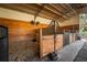 Inside view of a clean and sturdy horse stall with wood paneling, providing a safe haven at 11148 Lane Park Rd, Tavares, FL 32778