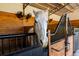 Close up of a horse in a stall with wood paneling and dual fans at 11148 Lane Park Rd, Tavares, FL 32778