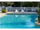 Inviting in-ground pool area featuring tiled edges and pristine white lounge chairs perfect for relaxing at 11148 Lane Park Rd, Tavares, FL 32778